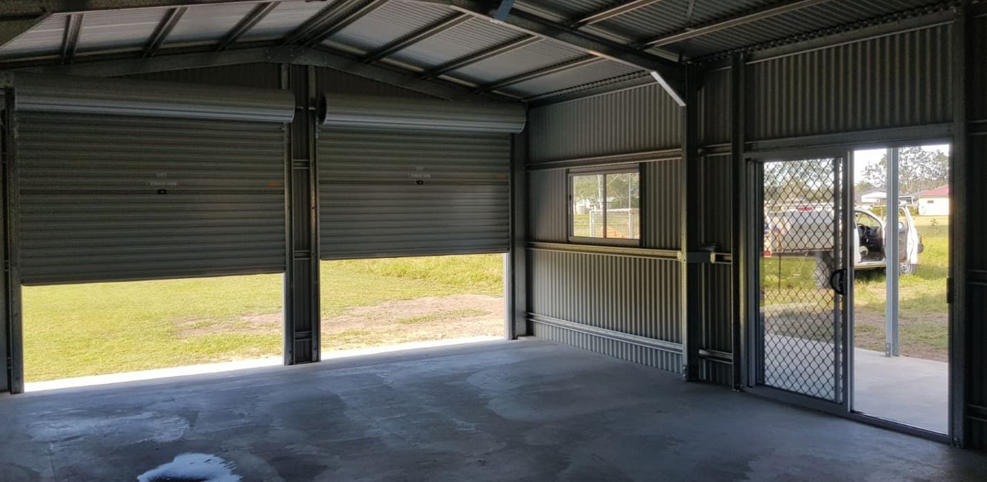 An Empty Garage With A Garage Door Open — Shed Constructions (QLD) In Gin Gin, QLD