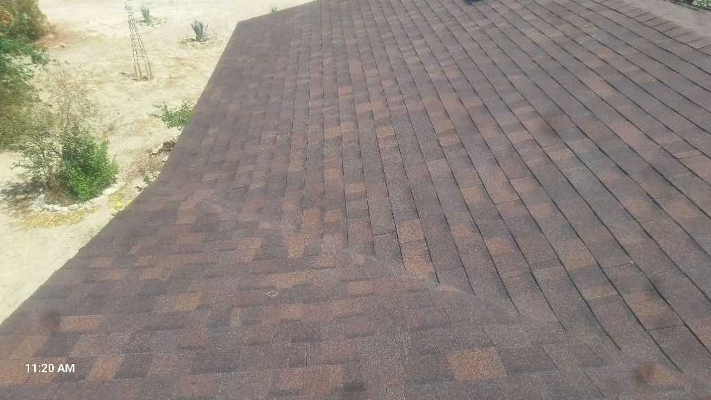 Brown shingled roof, some shingles appear damaged. Outdoor setting, daylight.