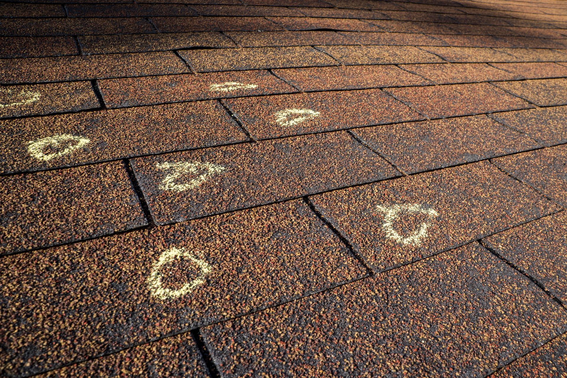 Marked storm damage on a residential roof. Marked storm damage on a residential roof.