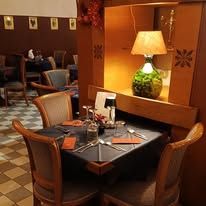 Interno del ristorante con tavoli, sedie e lampade. Decorazioni murali.