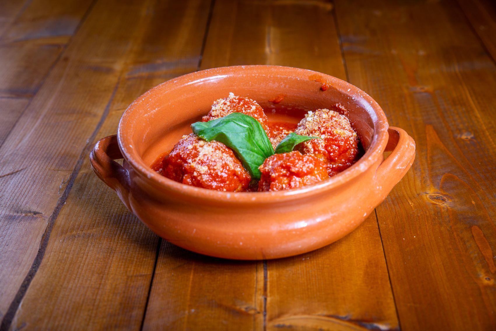 Pizza condita con mortadella, mozzarella, pistacchi e basilico.