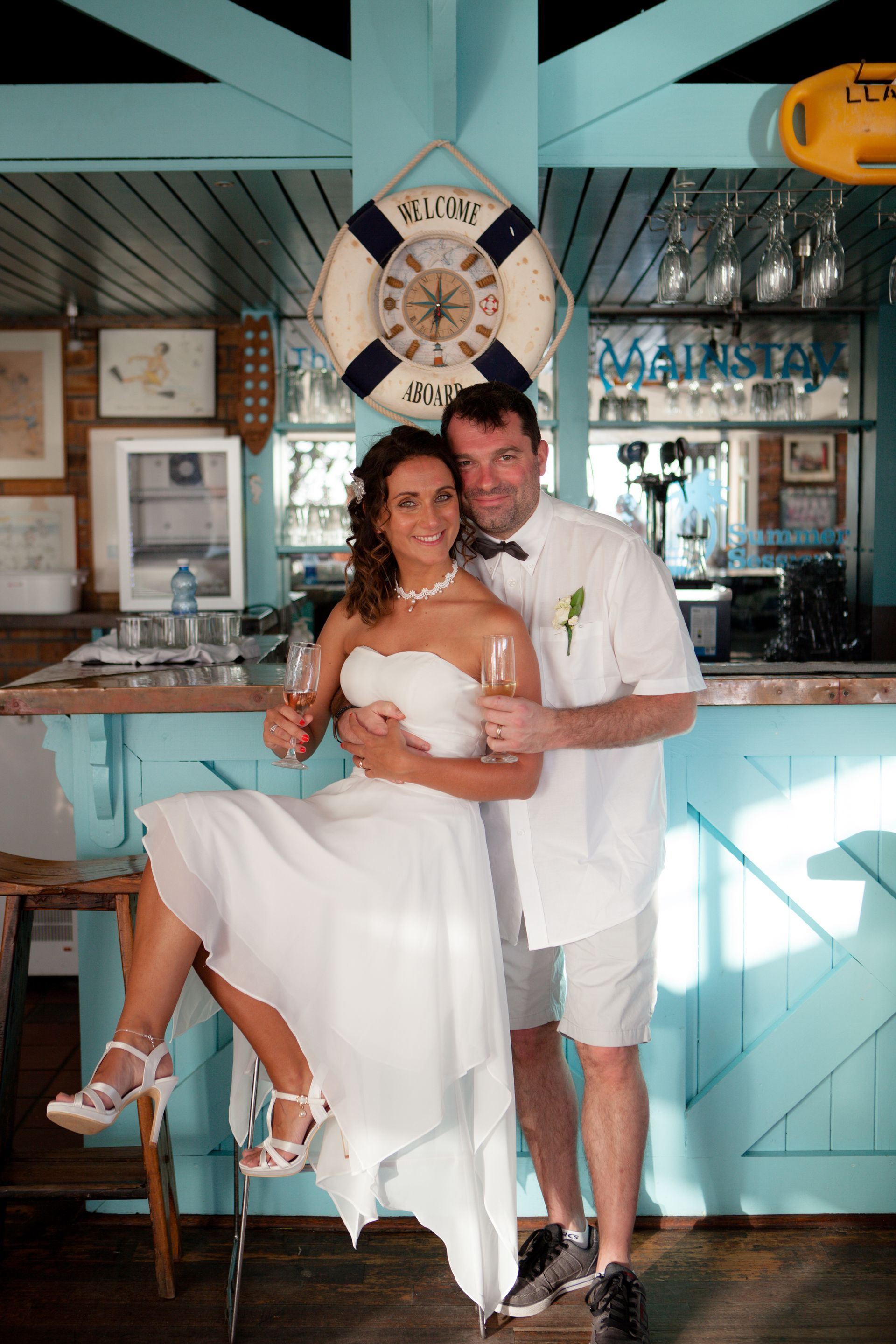 A man is holding a woman in his arms in front of a bar.