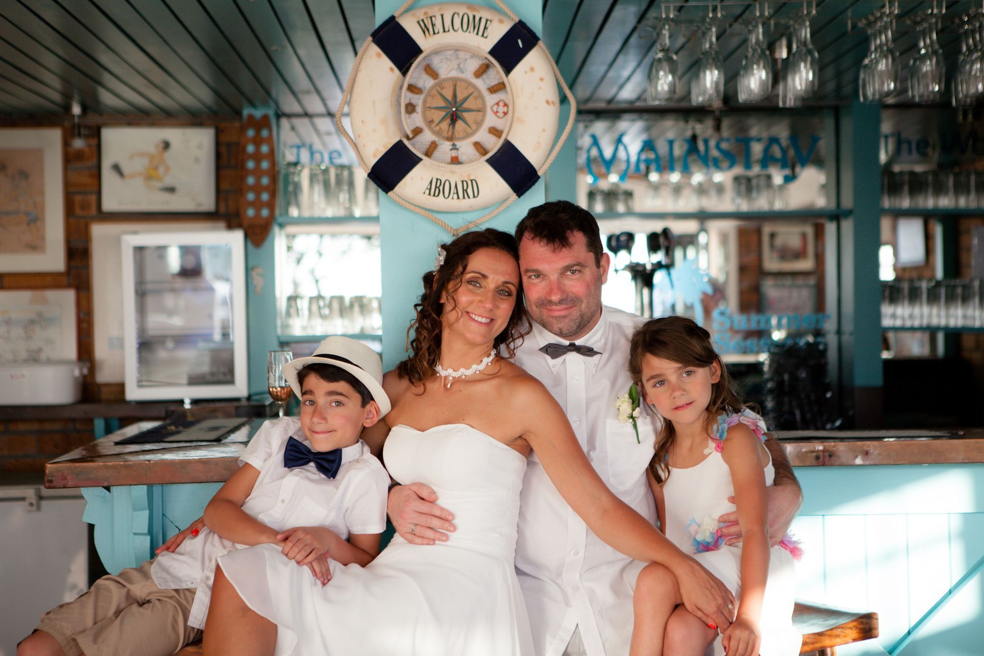 A bride and groom are posing for a picture with their children