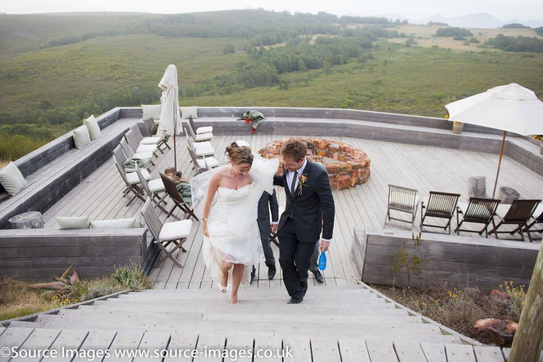 A bride and groom are walking down a set of stairs.