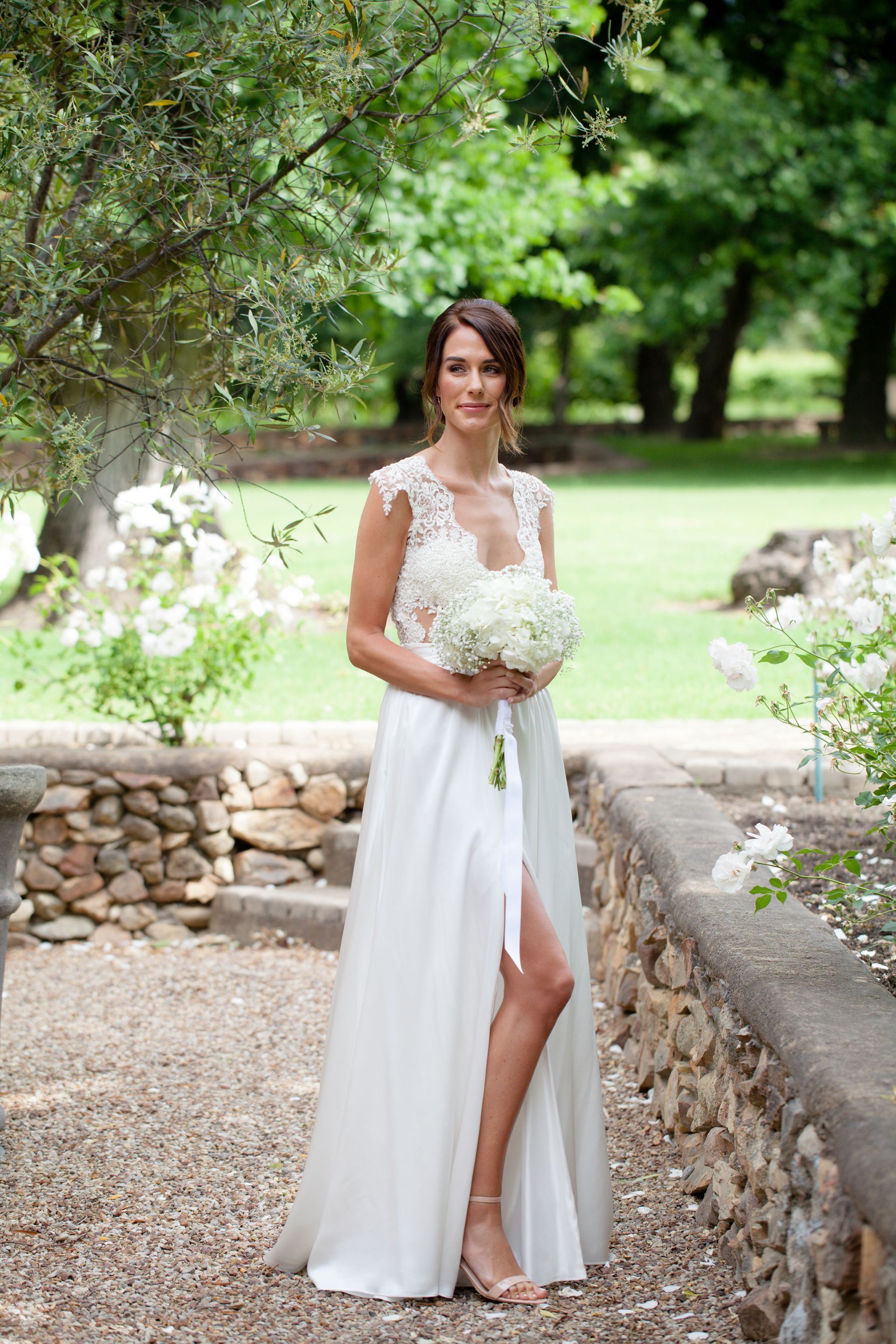 The bride is wearing a white dress and holding a bouquet of flowers.