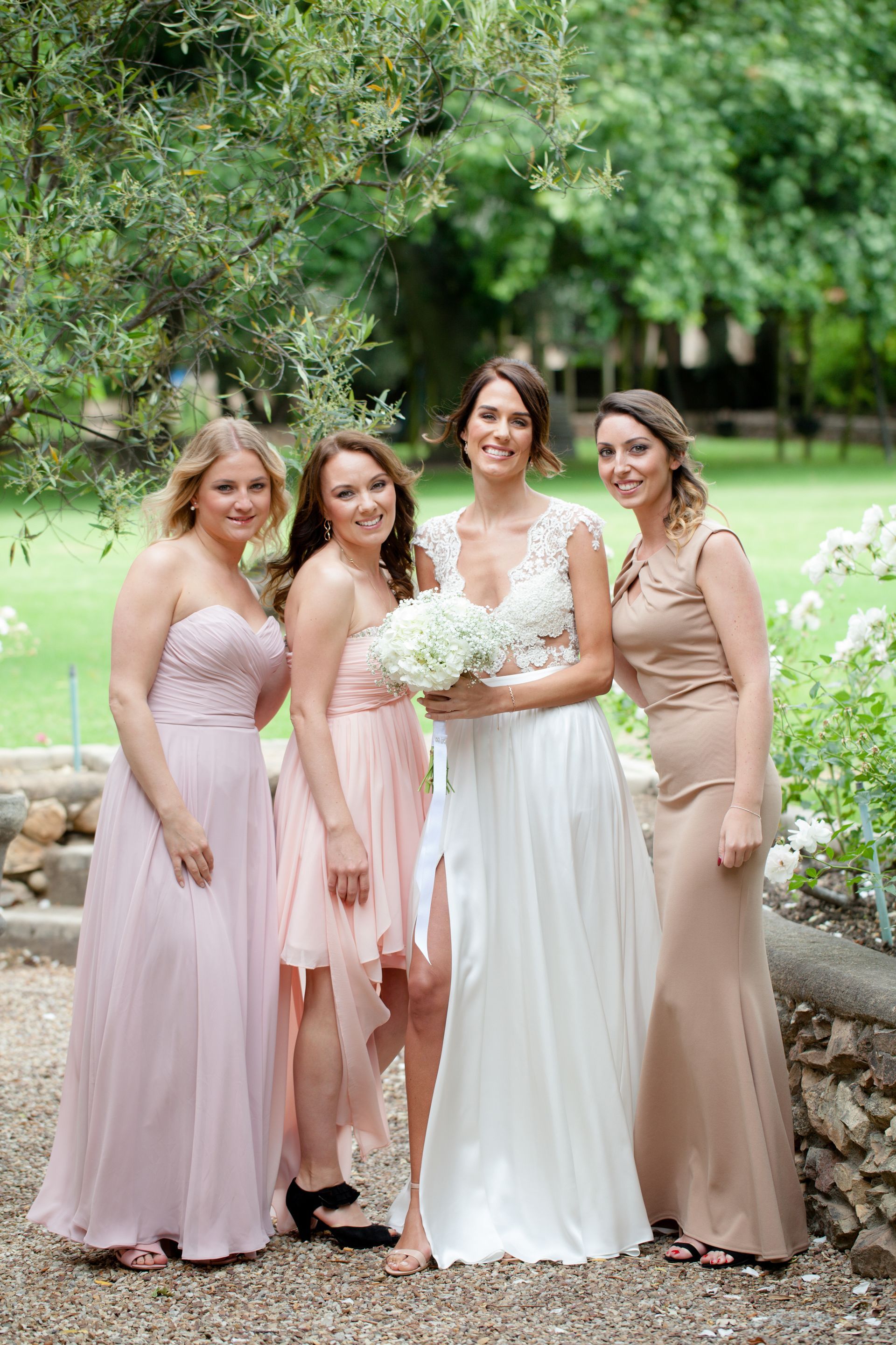 A bride and her bridesmaids are posing for a picture.