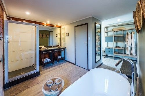 A bathroom with a bathtub and a walk in closet.