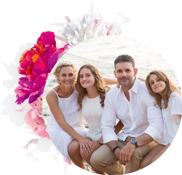 A family is posing for a picture on the beach.