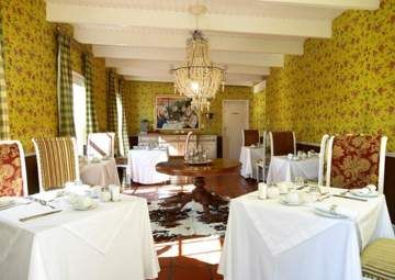 A dining room with tables and chairs and a chandelier.