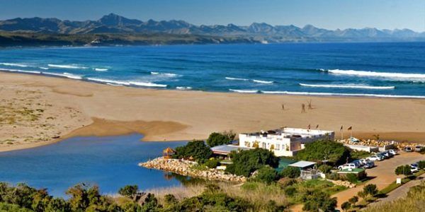 An aerial view of a beach with mountains in the background