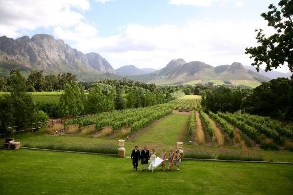 A group of people standing in a field with mountains in the background.