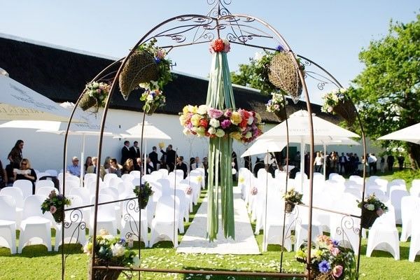 A wedding ceremony is taking place in a lush green field
