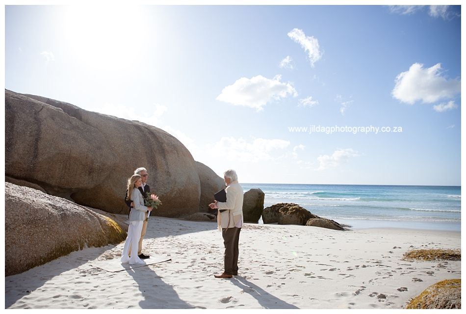 A man and a woman are standing on a beach near the ocean.