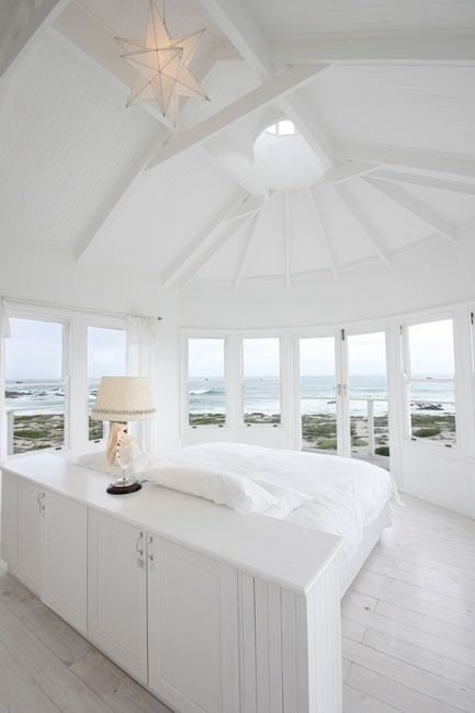 A bedroom with a large bed and lots of windows