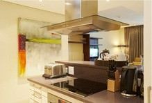 A kitchen with a stove top oven , toaster oven , and a hood.