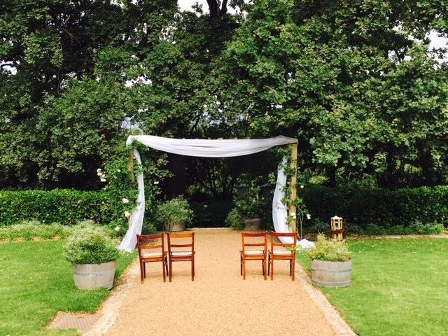 A row of chairs sitting under a white canopy in a park.
