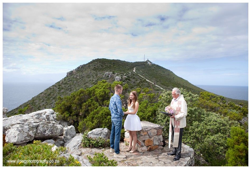 A man and a woman are getting married on top of a mountain.