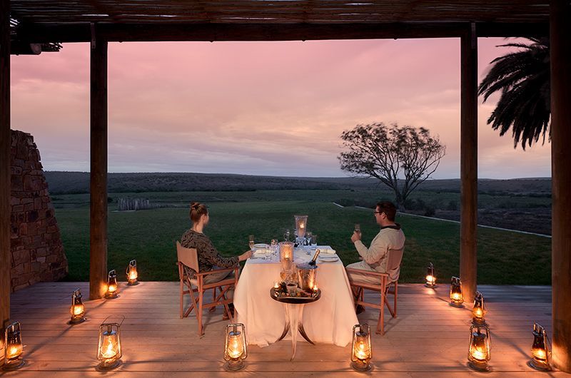 Two people are sitting at a table with a view of a field.