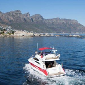 A boat is floating on top of a body of water with mountains in the background.