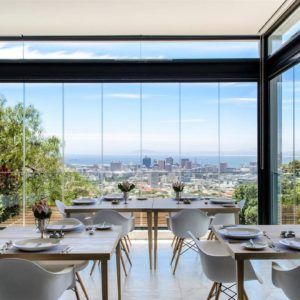 A dining room with tables and chairs and a view of a city.