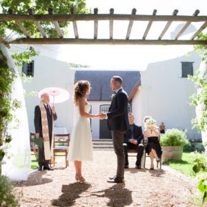 A bride and groom are shaking hands during their wedding ceremony