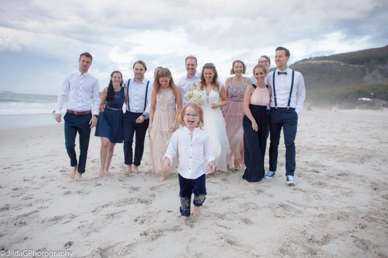 A group of people are posing for a picture on the beach.