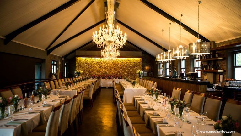 A long dining room with tables and chairs and a chandelier
