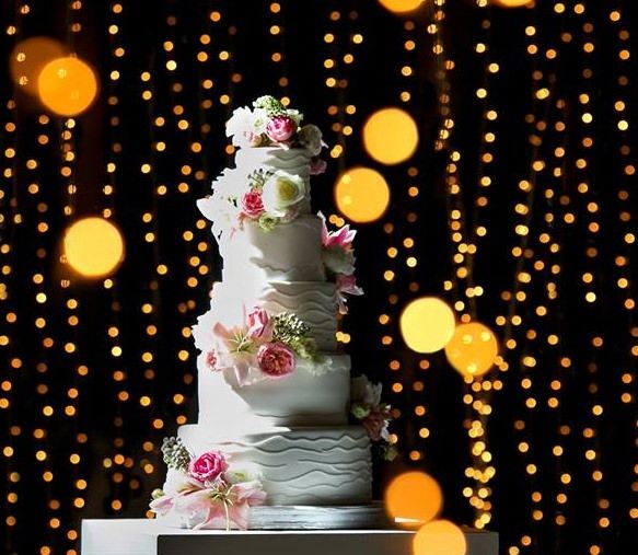 A wedding cake with flowers on it is sitting on a table.