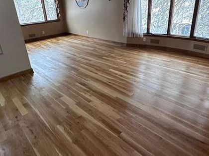 Hardwood flooring in a room with windows and beige walls.