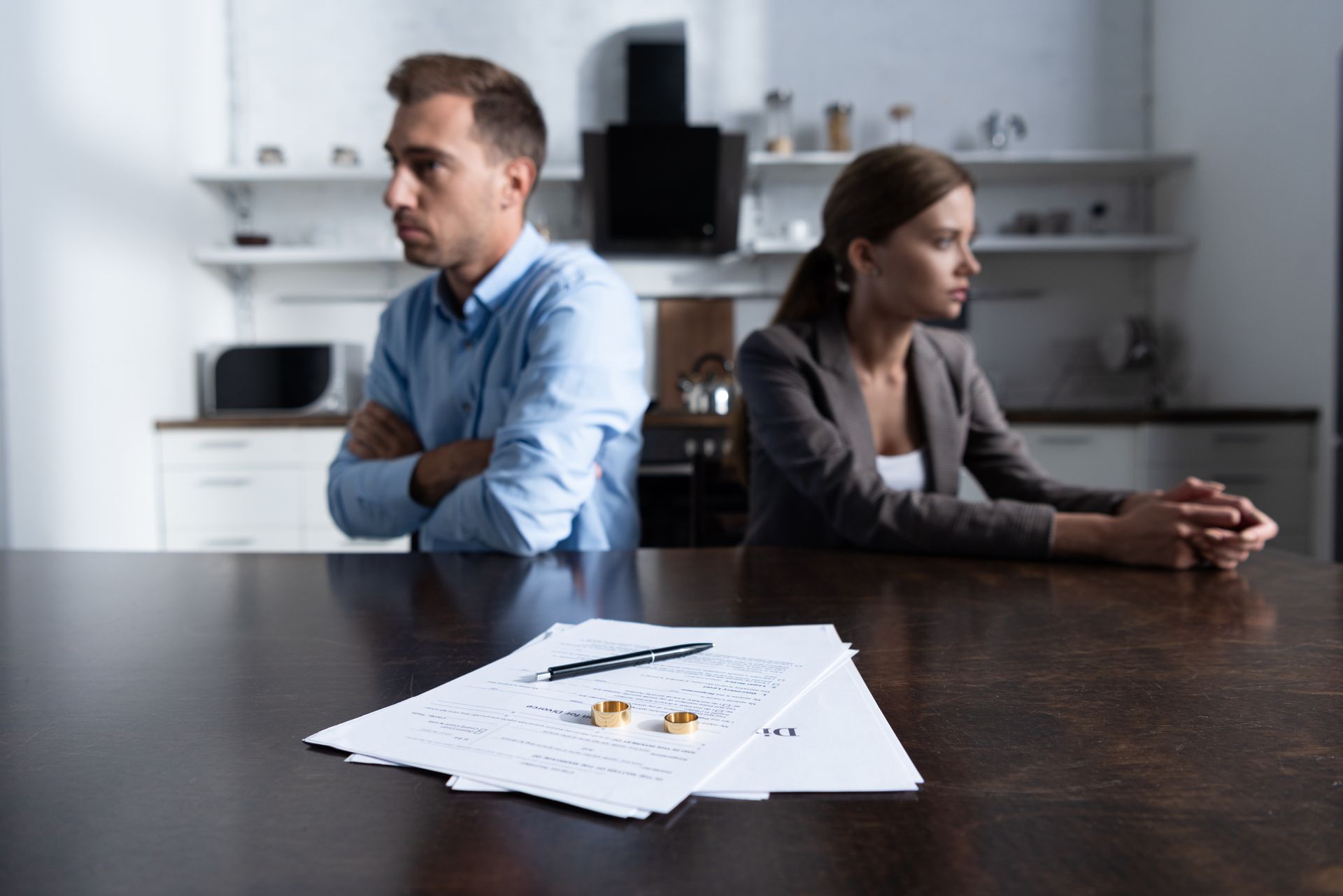 Selective focus of a couple sitting at a table with divorce documents.