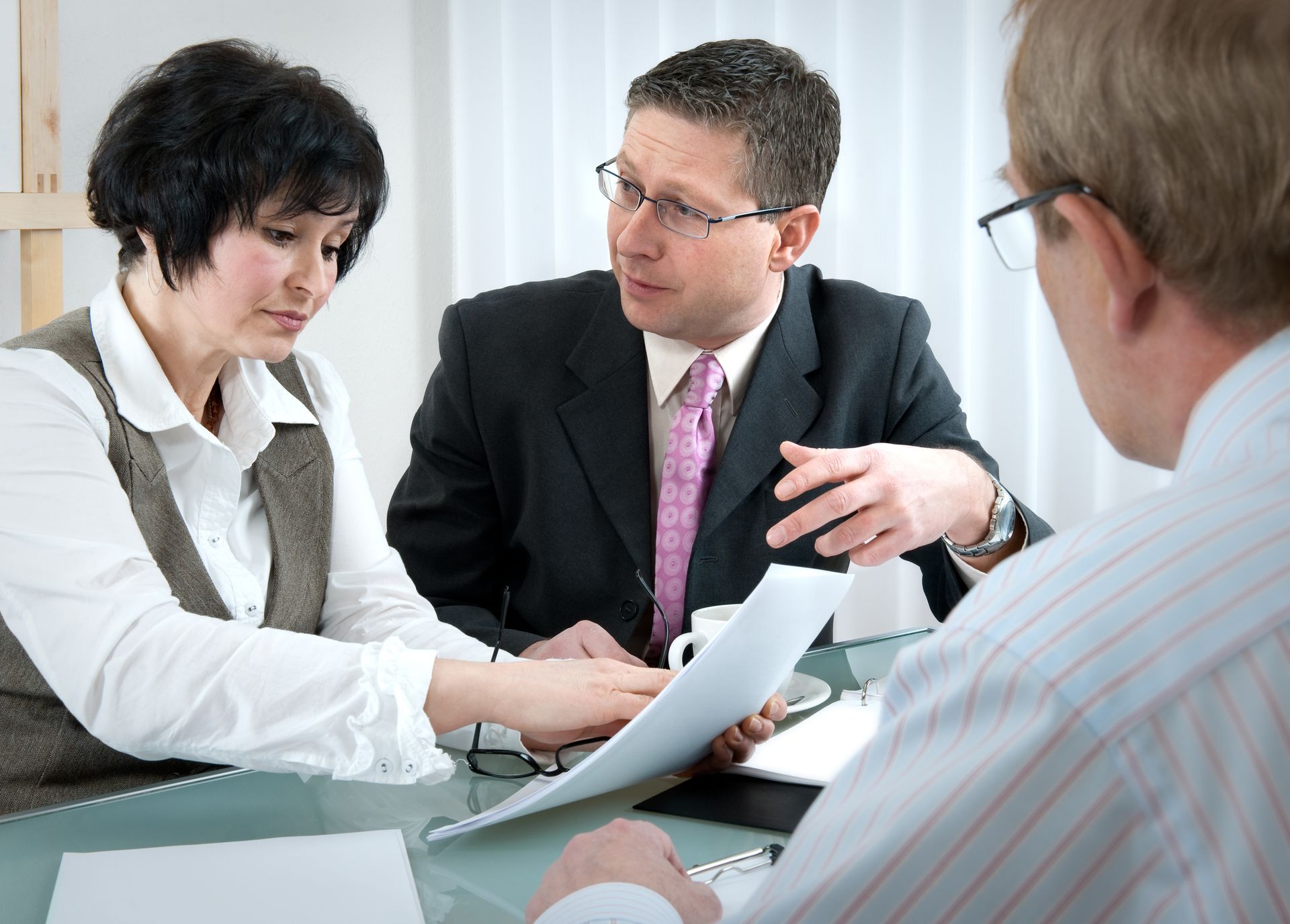 A couple is consulting with a divorce lawyer in a tense divorce settlement meeting.