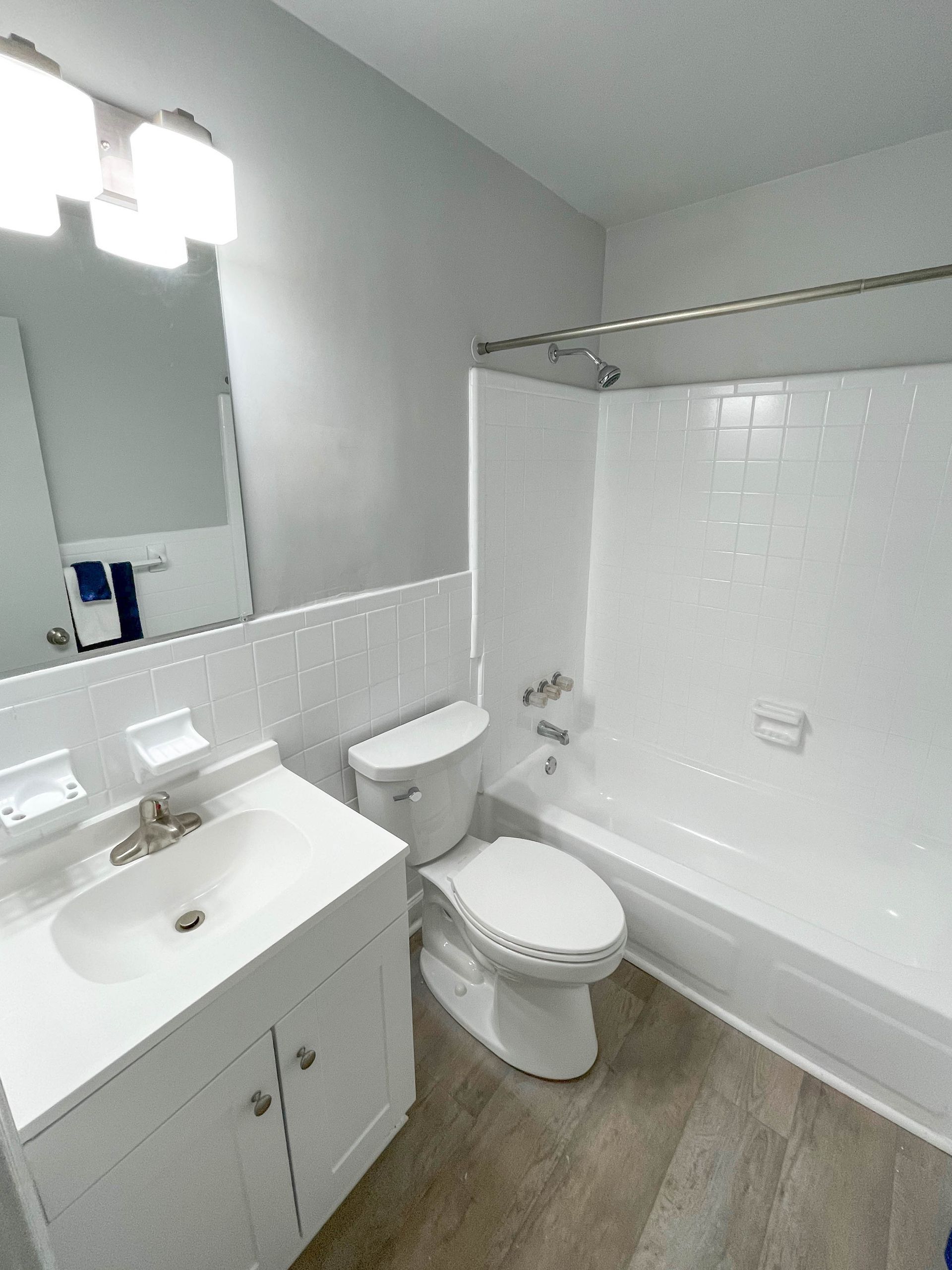 A bathroom with a toilet , sink , and bathtub.