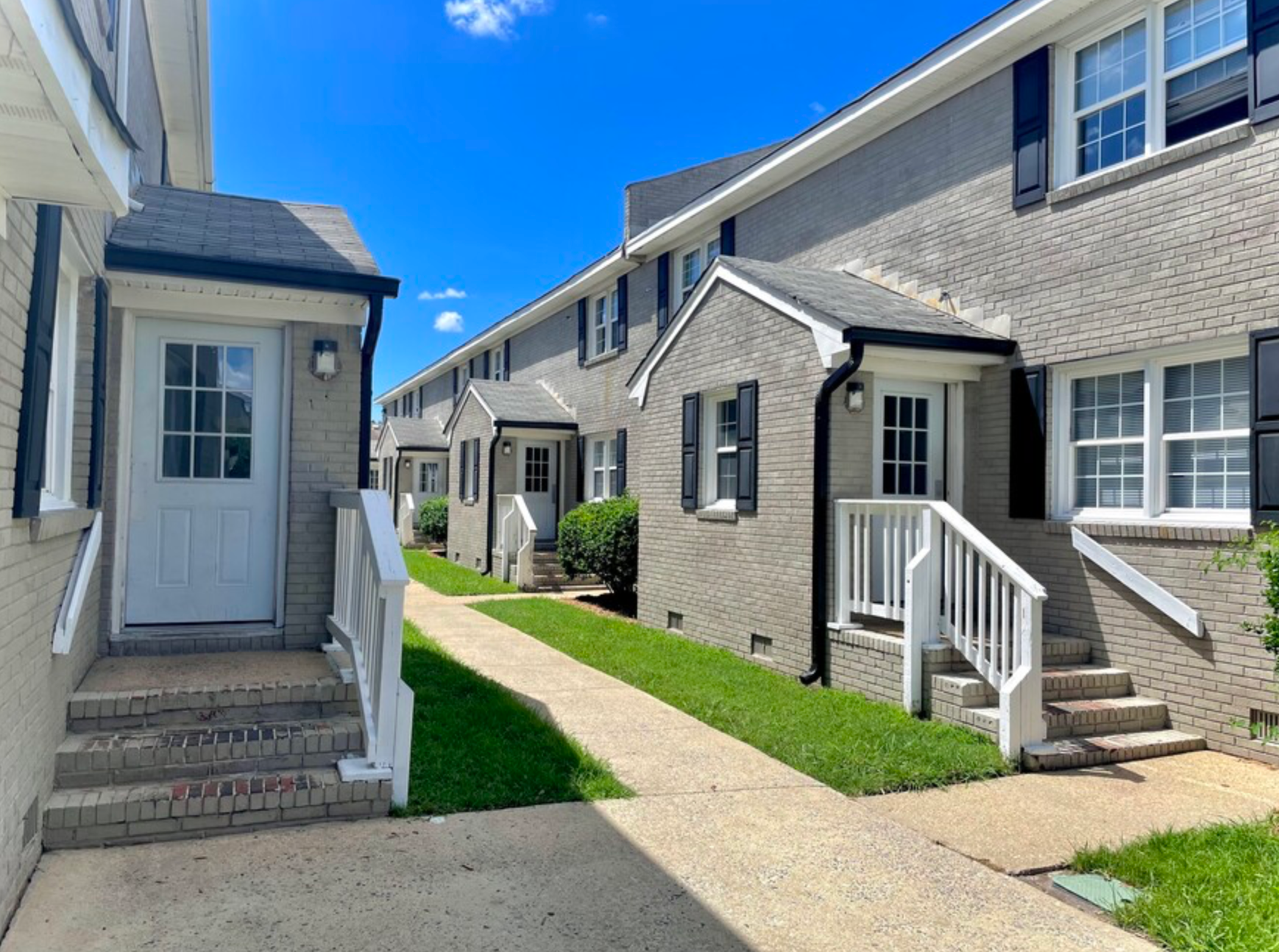 A row of houses with stairs leading up to the front door.