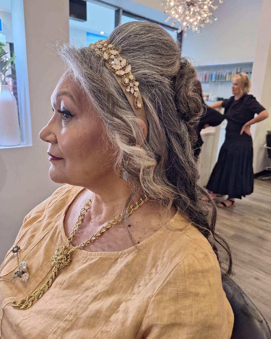 Woman With Long, Wavy Brown Hair Styled With Butterfly Hair Accessories — Artistry Of Hair in Redlynch, QLD