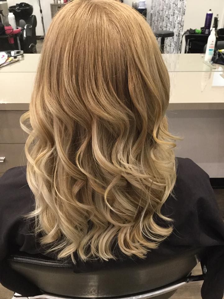 Woman With Long, Wavy Blonde Hair in a Salon Setting — Artistry Of Hair in Redlynch, QLD