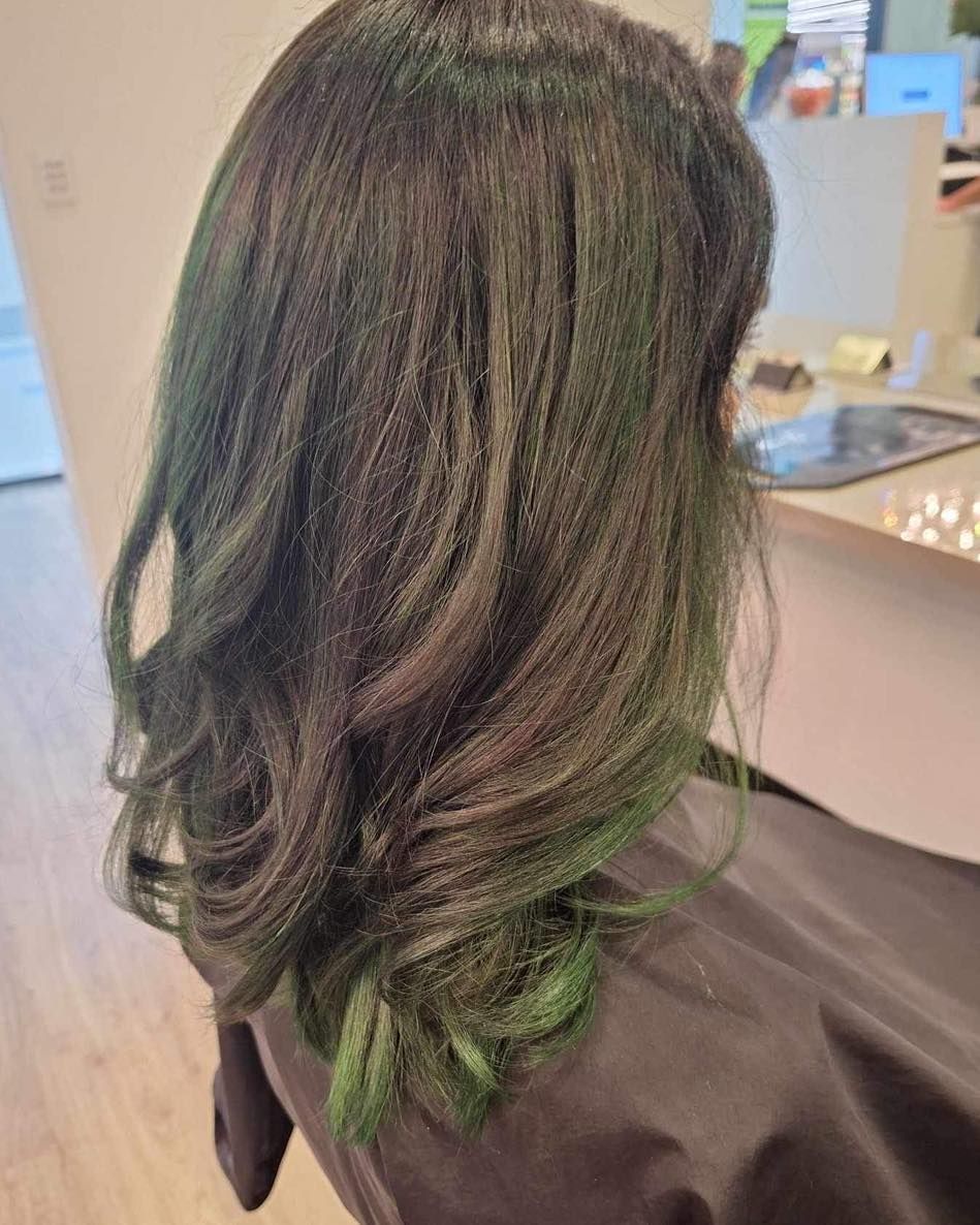 Woman's Dark Hair Styled With Subtle Green Highlights, Layered and Wavy — Artistry Of Hair in Redlynch, QLD