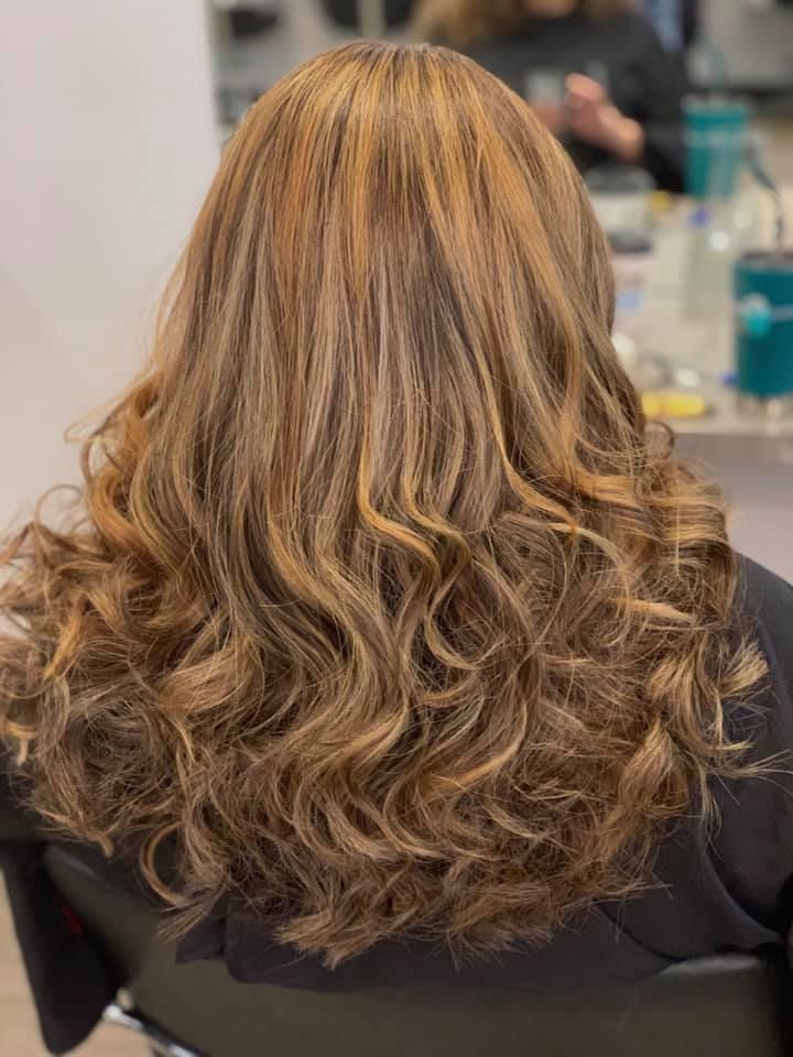 Wavy, Highlighted Brown Hair. Warm Tones and Curls, Likely Styled at a Salon — Artistry Of Hair in Redlynch, QLD