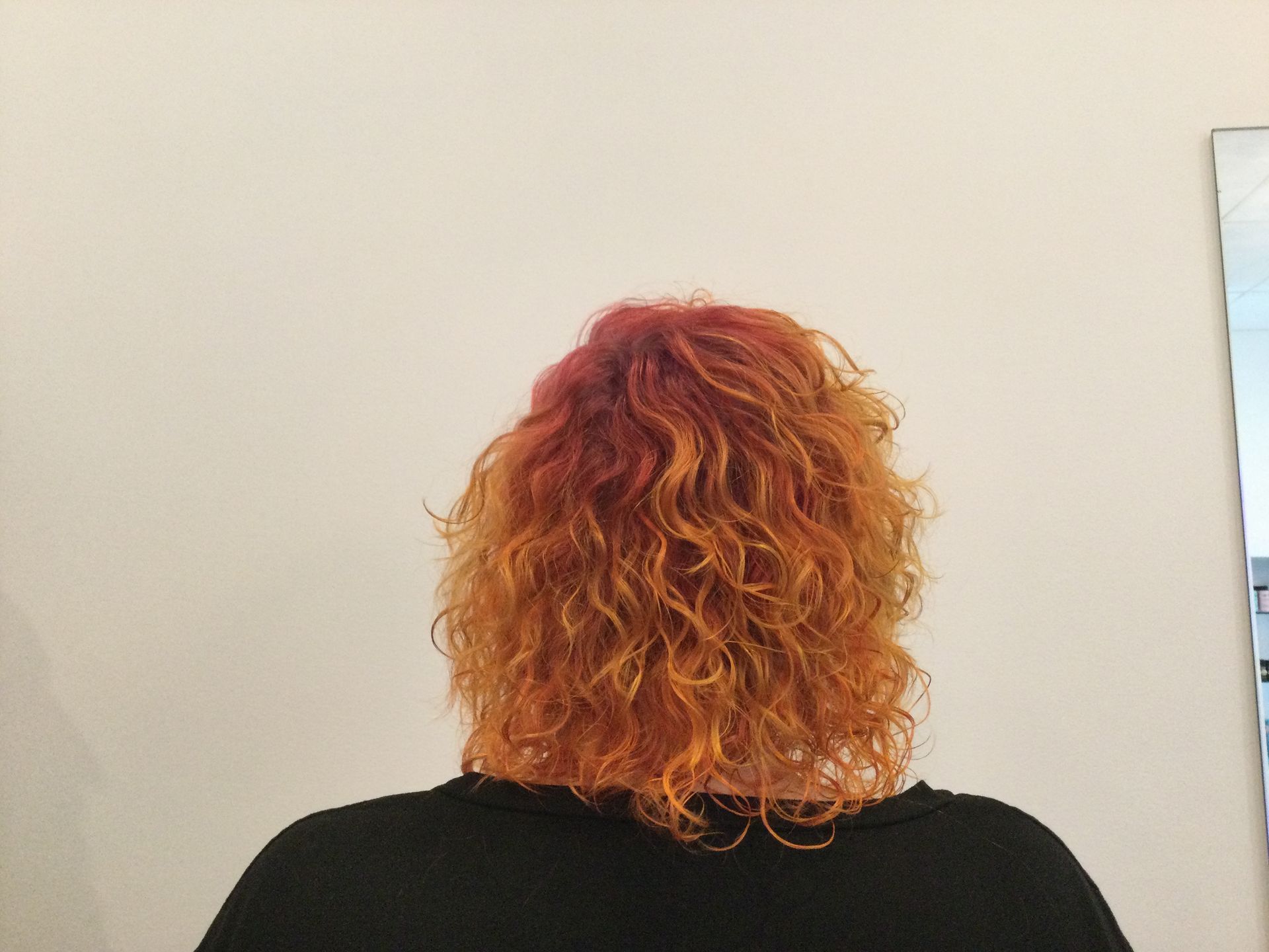 Person Getting Hair Curled With a Curling Iron in a Salon — Artistry Of Hair in Redlynch, QLD