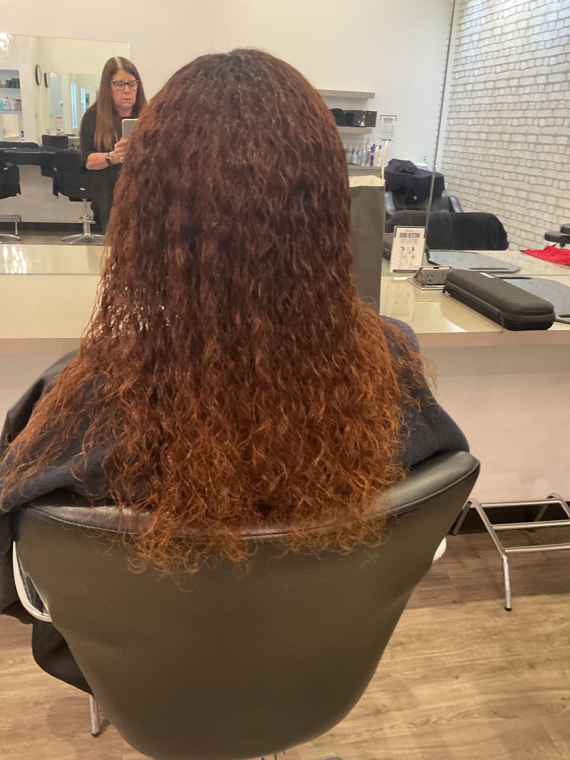 Woman With Long, Wavy Brown Hair With Blonde Highlights at a Salon — Artistry Of Hair in Redlynch, QLD