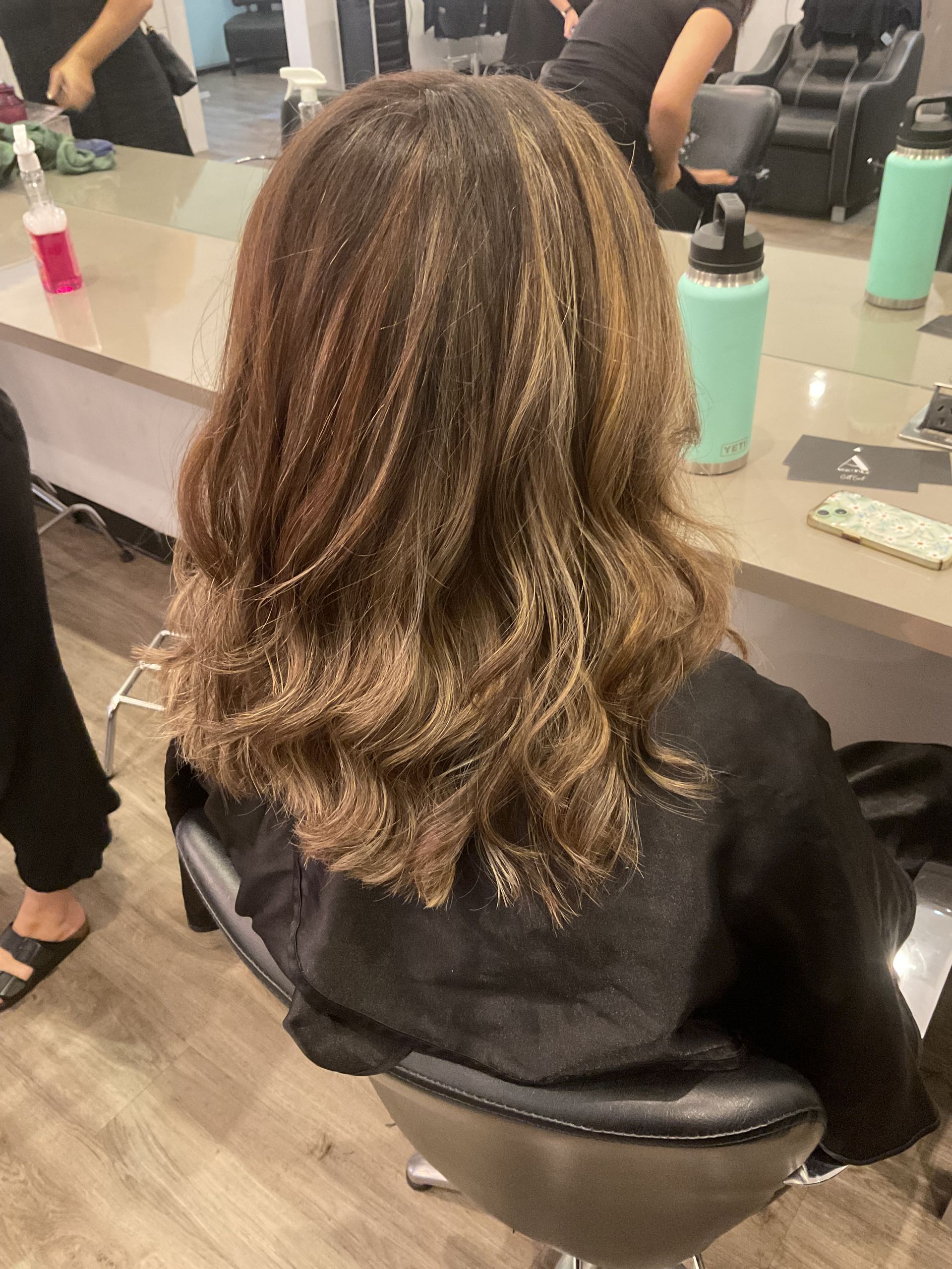 Hair Stylist Blow-drying Client's Hair With Round Brush and Hair Dryer in a Salon — Artistry Of Hair in Redlynch, QLD