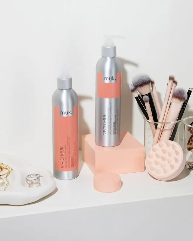Haircare Bottles With Pink Labels on a Shelf With Makeup Brushes and Accessories — Artistry Of Hair in Redlynch, QLD