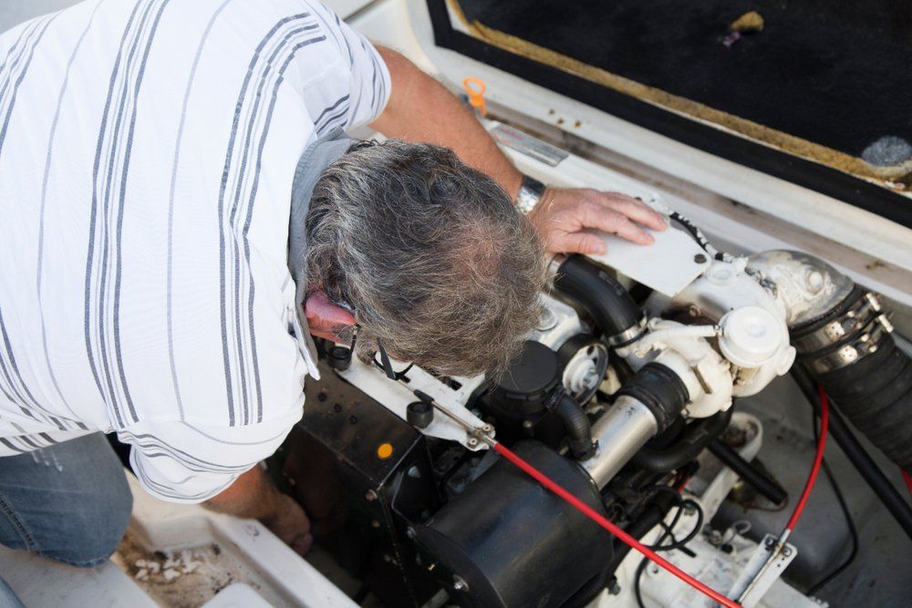 Man Repairing Boat Engine Under Sunny Day — KG Mechanical Services in Bungalow, QLD