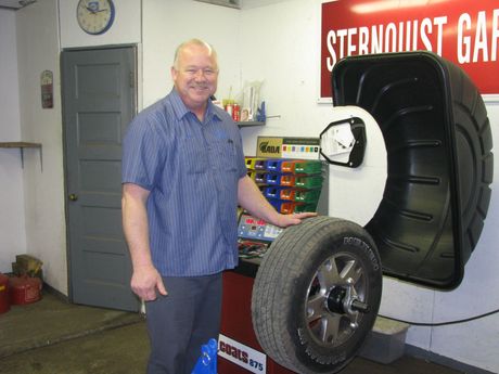 Auto Repair & Service — Man Smiling While Holding Tire in Boone, IA