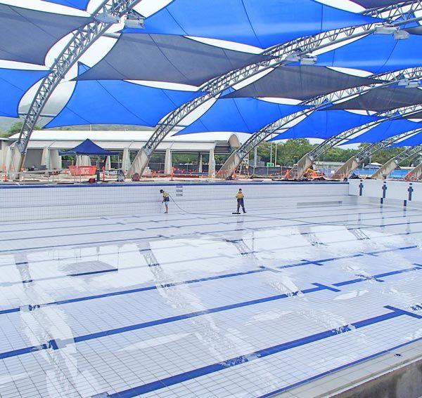 workers cleaning and waterblasting pool floor