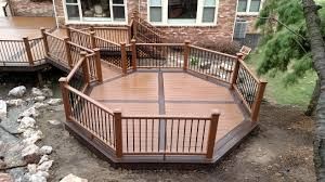 Wooden octagon-shaped deck with railings attached to a house.
