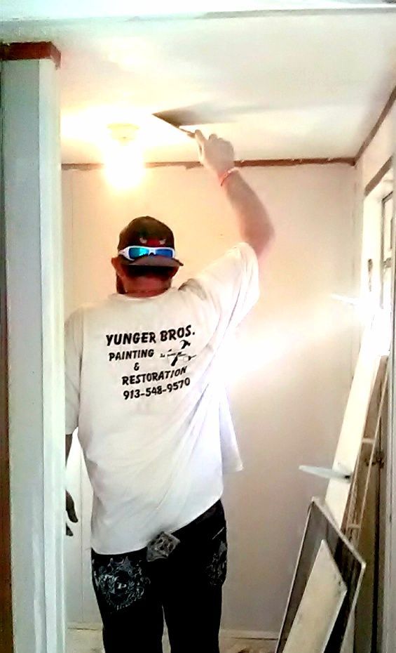 New tan commercial building with blue awnings, partially paved parking lot, and cloudy sky.