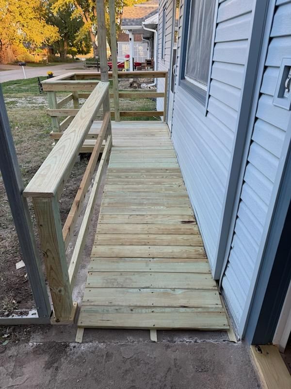 Wooden ramp with handrails attached to a house for accessibility.