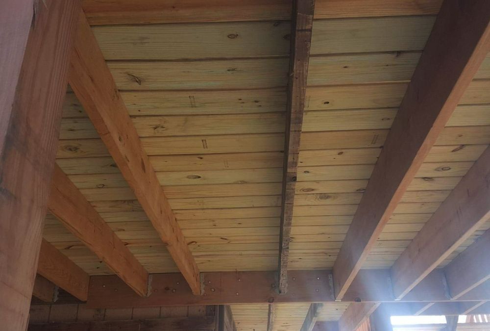 Wooden ceiling under construction, with visible beams and planks.