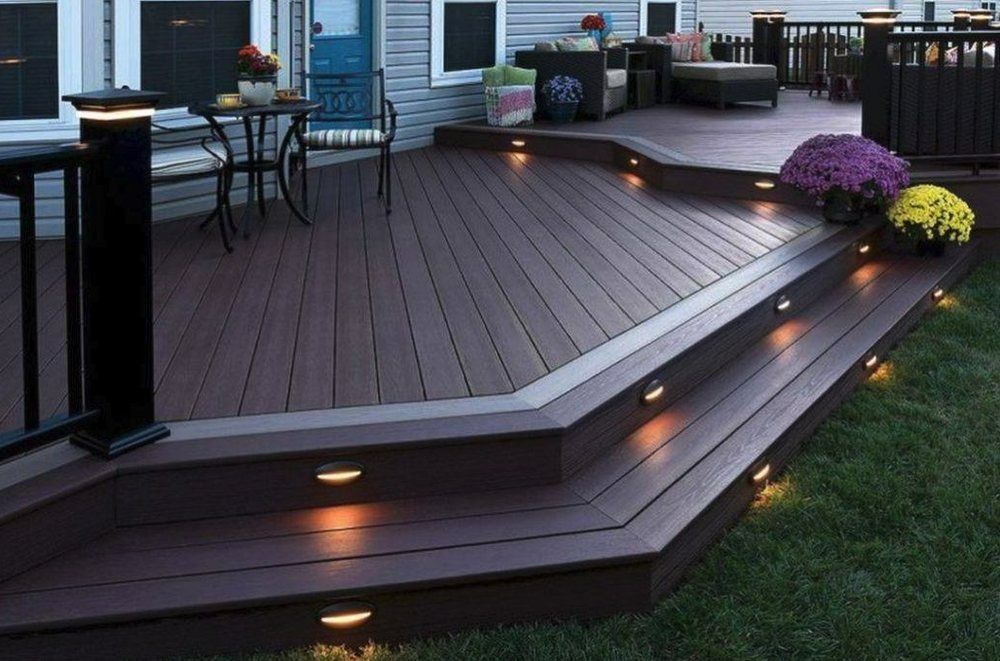 Wooden deck with built-in lights, steps, and black railing. Outdoor setting with potted flowers.