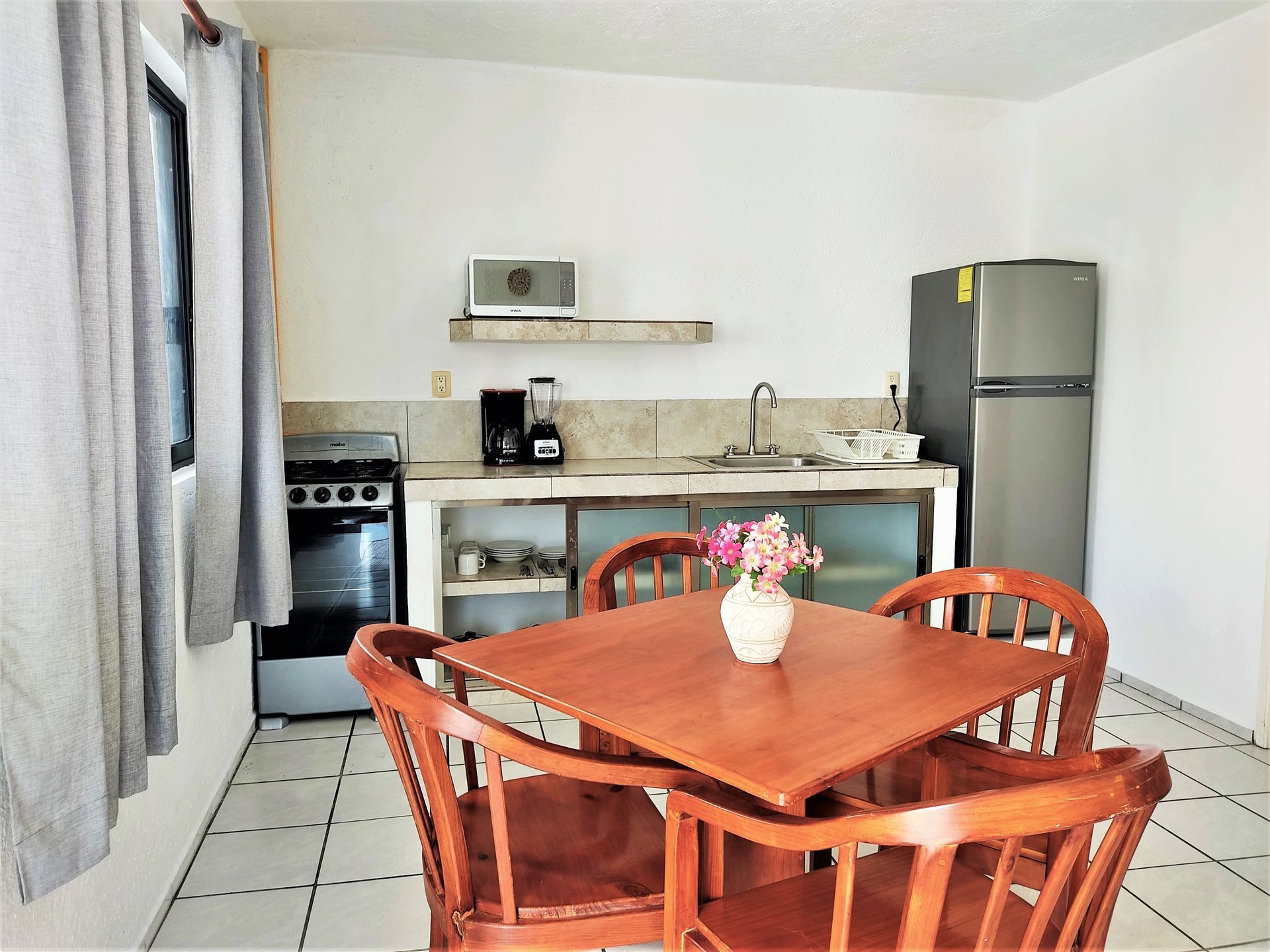 Una cocina con mesa y sillas y un refrigerador.